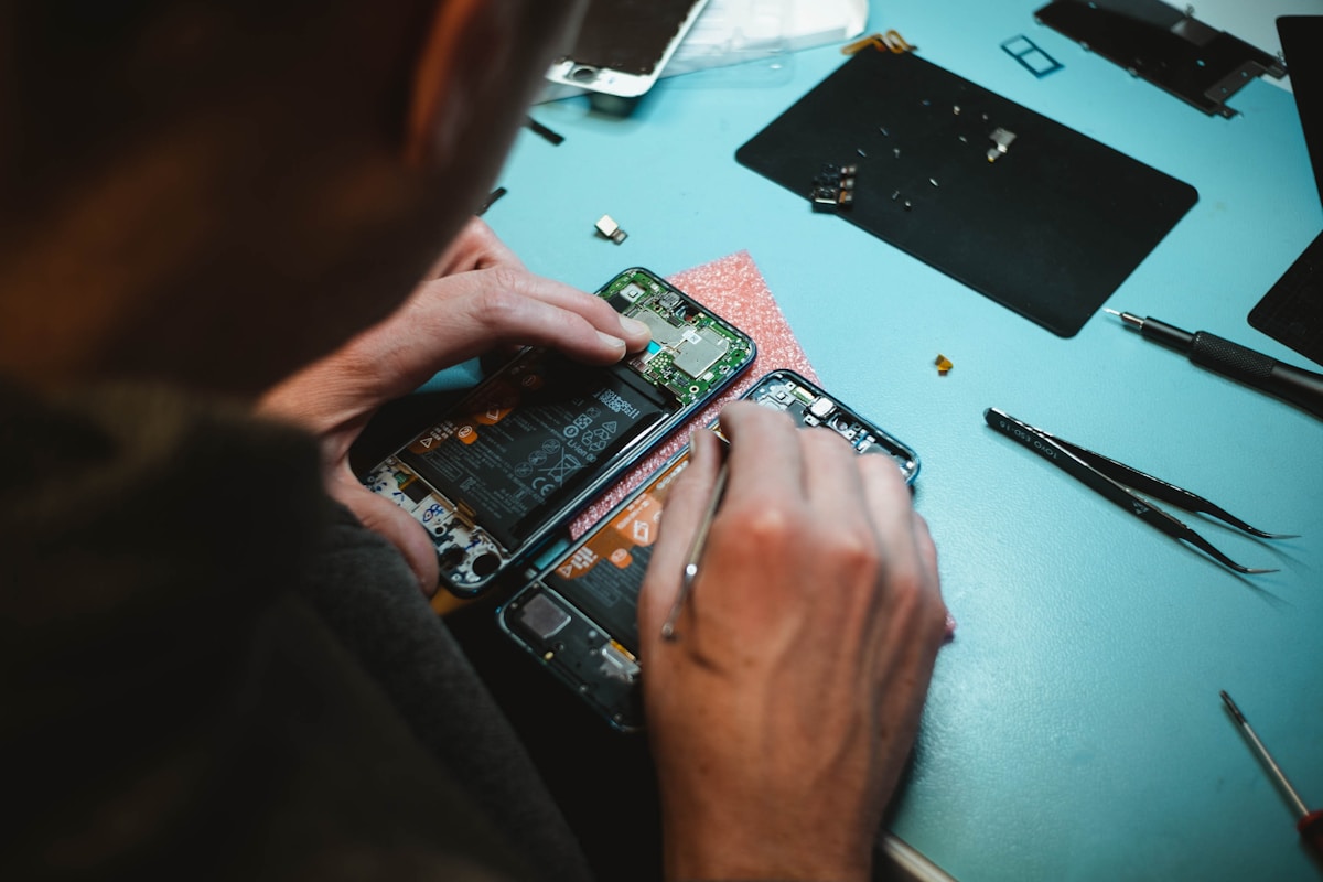 Técnico da NipoCell realizando manutenção de celular em Dourados